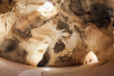 Mağaranın duvarları çeşitli kayalarla hayrete düşürür. Beit Guvrin parkı, İsrail. Bell Mağaraları - MS 7. yüzyılın taş ocakları. Tavandaki güneş ışığı mağaranın mahzenlerini aydınlatır.. 