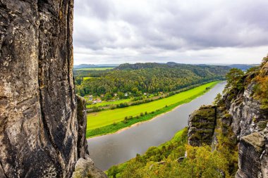 Elbe Nehri 'nin 200 metre yukarısındaki Bastei' nin kumlu kayalıkları ünlü bir turistik merkezdir. Almanya. Muhteşem Alman nehri Elbe. Sakson İsviçre 'de Malerweg Sanatçılar Yolu.