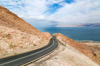 Deniz kıyısı boyunca muhteşem asfalt yol. Dünyanın en tuzlu denizi, Ölü Deniz. Musevi Çölü dünyadaki en ünlü çöllerden birisidir. İsrail, kış bulutlu bir gün. 