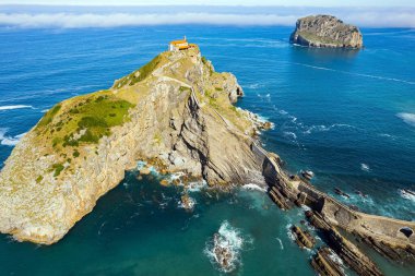 Büyülü manzara. İspanya 'nın en sıra dışı kıyıları. Gastelugache adası bir köprü ve dolambaçlı bir merdivenle anakaraya bağlandı. Fotoğraf bir İHA 'dan çekildi. Biscay Körfezi.