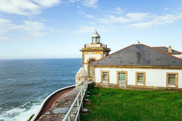 Watchtower Chapel and Lighthouse. Beautiful stone paved highway. Unusual impressive architecture of the Luarca. Atlantic coast, Asturias. Romantic trip to Spain.