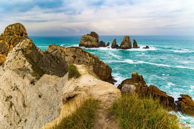 Biscay Körfezi 'nde fırtınalı bir sonbahar günü. Portio plajı. Resimli kayalıklar ve büyük taşlar okyanusa karşıdır. İspanya kıyıları, Cantabria. Atlantik Okyanusu 'nun Rocky sahili.. 