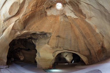 Bell Mağaraları - MS 7. yüzyılın taş ocakları. Mağaranın duvarları çeşitli kayalarla hayrete düşürür. Beit Guvrin parkı, İsrail. Tavandaki güneş ışığı mağaranın mahzenlerini aydınlatır.. 