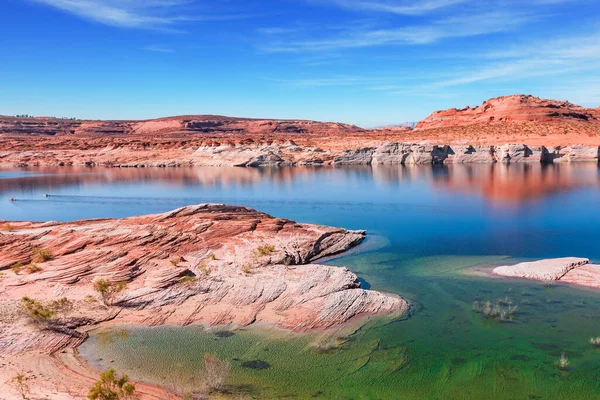 パウェル湖 湖の滑らかなエメラルド色の水は砂岩の海岸と対照的です アメリカだ 海岸は狭い峡谷によって切断されます 水は周囲の海岸を反映している — ストック写真