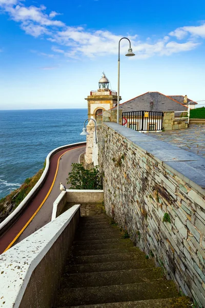 Stone steps on the road to the lighthouse. Road to Watchtower Chapel and Lighthouse. The majestic Atlantic Ocean. Asturias. Romantic trip to Spain. Unusual impressive architecture of the Luarca.