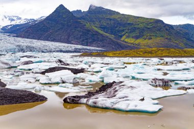  İzlanda. Soğuk dağların arasındaki buzullar ve buzdağları. Jokulsarlon buzul gölü. Buz kütleleri pürüzsüz suya yansır. Kuzey Kutbu 'nda soğuk yaz. 