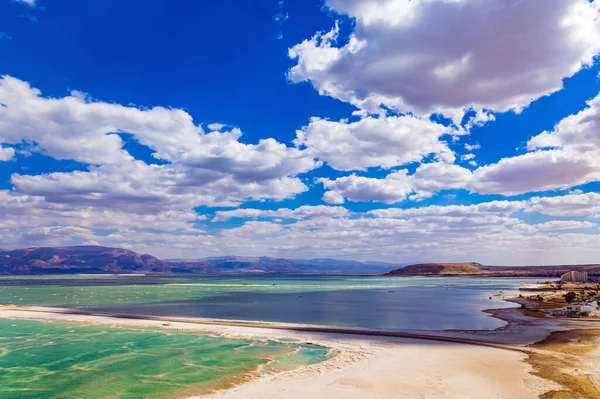 素晴らしい死海 イスラエルだ 蒸発した塩は水から出てくる 水は空の明るい青を反映しています 緑豊かな積雲が水の中に反映されます ドローン映像 明るい3月の日 — ストック写真