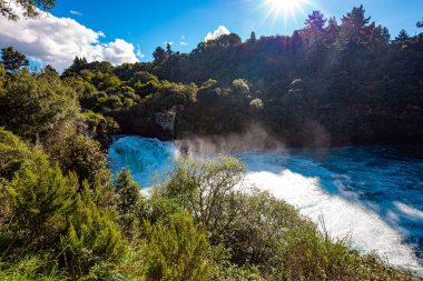 Turkuaz suyun üzerinde kar beyazı köpük uçar. Huka Şelalesi 'nin gürültülü ve köpüklü şelalesi. Waikato Nehri, Kuzey Adası, Yeni Zelanda. 