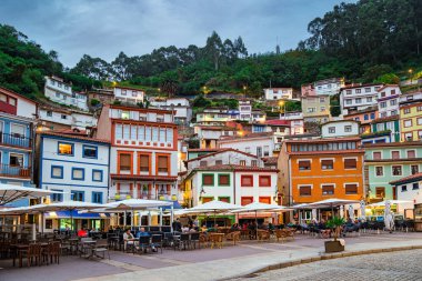 CUDILERO, İspanya - 09 Ekim 2022 Cudillero bir dağ yamacına tünemiş pitoresk bir balıkçı limanı. Köy, okyanus körfezi etrafında bir amfitiyatrodur. Asturyalar. İspanya. Atlantik 'te akşam karanlığında