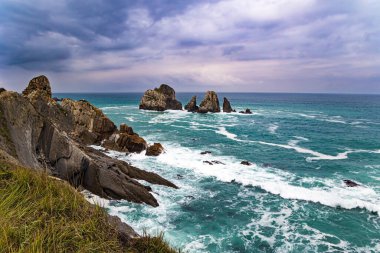 Portio plajı. Atlantik Okyanusu 'nun Rocky kıyı şeridi. Biscay Körfezi 'nde fırtınalı bir sonbahar günü. Resimli kayalıklar ve devasa taşlar okyanusa direniyor.