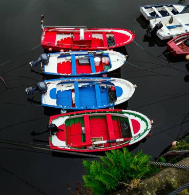 Limana demirlemiş renkli renkli balıkçı tekneleri var. Luarca, Atlantik kıyısı, Asturias. Körfezdeki resim gibi balıkçı limanı ve demirli eğlence yatları. İspanya 'ya romantik bir gezi. 