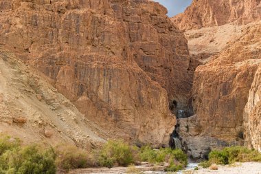 Dar bir vadide çağlayan şelale. Şiddetli kış yağmurlarından sonra Ölü Deniz 'in etrafındaki Yahudi Çölü. İsrail, kış bulutlu bir gün.