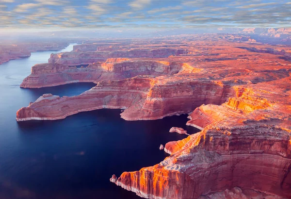 Landscape under the wing of an airplane. U.S. The coast of Lake Powell is cut by narrow canyons. Grandiose huge lake of artificial origin among the picturesque red sandstone cliffs.