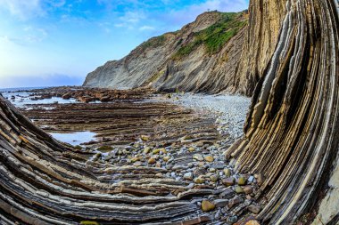 İnanılmaz derecede tuhaf sahil kayalıkları. Sinek, sular çekildiğinde ortaya çıkan su altı kayalarının benzersiz manzarası. Playa Zumaya. Bask Ülkesi, Itsurun. Biscay Körfezi kıyısında, Atlantik. 