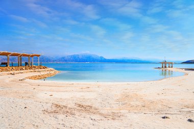 İsrail kıyıları. Su yüzeyindeki buharlaşmış tuz kristalleri. Ölü Deniz, Orta Doğu 'da çok tuzlu ve endorheik bir göldür. Ölü Deniz 'deki ünlü tatil köyü.. 