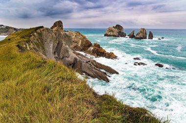 Portio plajı. Biscay Körfezi 'nde fırtınalı bir sonbahar günü. Resimli kayalıklar ve büyük taşlar okyanusa karşıdır. Atlantik Okyanusu 'nun Rocky kıyı şeridi. İspanya kıyıları, Cantabria