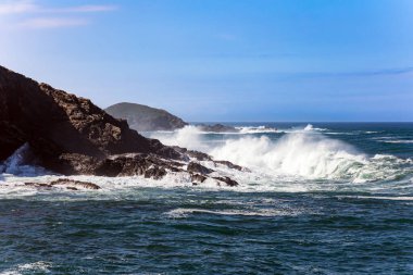 Büyük okyanus dalgaları taştan dalgalara vuruyor. Muhteşem Atlantik Okyanusu. Körfezdeki Luarca şehrinin pitoresk balıkçı limanı. İspanya 'ya romantik bir gezi. Asturyalar. 