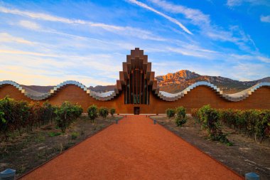 Bodegas Ysios 'un muhteşem modern mimarisi. Günbatımının parlak alevli renkleri. Sıcak İspanyol sonbaharına yolculuk