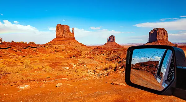 The car mirror reflects the scenic landscape. The famous rock Mitten. USA. Navajo Indian Reservations. Monument Valley