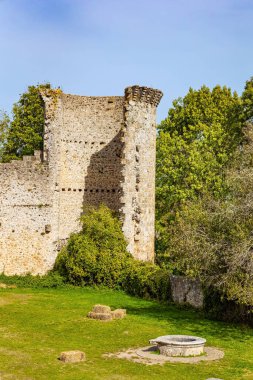 Taş yuvarlak kuyu. Kale avlusu çimlerle kaplanmış. Chevreuse 'deki Chateau de la Madeleine. Fransa. Ile-de-France bölgesi. 