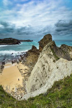Cantabria Plajları, Portio Plajı. Atlantik kıyısında rüzgarlı bir gün. Dev, pürüzsüz gri kayalar ve pürüzsüz kumsal. İspanya Playa di Arnia plajında öğle vakti.