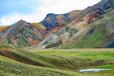 Yeşil otlarla kaplı dev bir bataklık. Landmannalaugar 'ın renkli dağları ve termal pınarları. Egzotik İzlanda 'ya seyahat. 