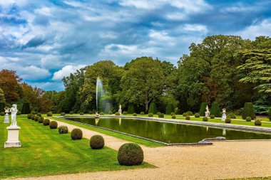 Parkta çeşmesi olan büyük dikdörtgen yüzme havuzu. Breteuil 'in antik şatosunu çevreleyen güzel bir park. Çizmeli Kedi 'nin Breteuil Kalesi' ni ele geçirmesi. Fransa.