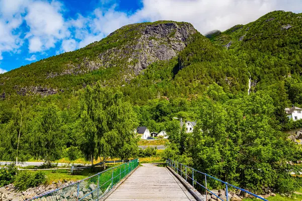 Bridge over the lake. Huge, lovely lake surrounded by picturesque round hills. Sunny weather in Norway. Wonderful fresh green forest