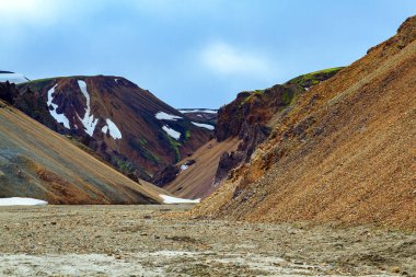 İnanılmaz İzlanda - turistler ve fotoğrafçılar için rüya. Landmannalaugar. Rhyolite dağları, katılaşmış lav akıntıları ve geçen yılki karın kalıntıları. 