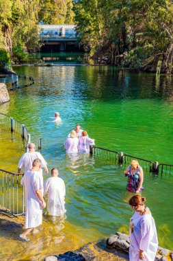 YARDENIT, ISRAEL - 21 HAZİRAN 2023: Yardenit, Katolikler ve Ortodoks Hıristiyanlar için bir vaftiz merkezidir. Güneşli kış günü. Soğuk su hacıları korkutmaz..