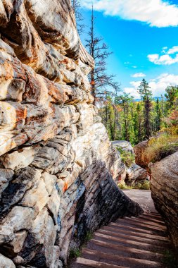 Açılış kapağı kayalar arasında katmanlı bir geçit. Kanada Kayalıkları. Athabasca Şelalesi, Alberta. Jasper Ulusal Parkı. 