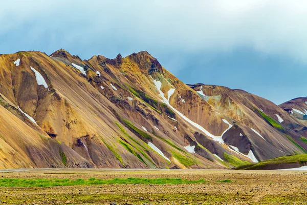 Landmannalaugar 'ın renkli dağları. Egzotik İzlanda 'ya git. Geçen yılki karın kalıntıları ve sıcak termal maden suyu kaynakları.