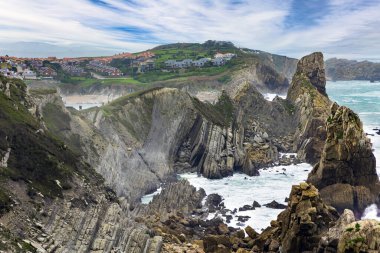 Cantabria 'da. İspanya 'nın Playa di Arnia plajında öğle vakti. Atlantik kıyısında rüzgarlı bir gün. Rocky resimli okyanus kıyısı.