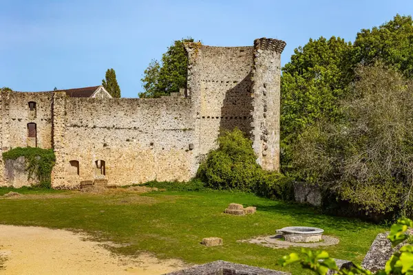 Kale avlusu çimlerle kaplanmış. Savunma duvarları ve yuvarlak taş kuyu. Chevreuse 'deki Chateau de la Madeleine. Fransa. Ile-de-France bölgesi. 