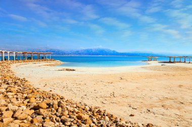 İsrail 'in ünlü tatil beldesi. Ölü Deniz, Orta Doğu 'da çok tuzlu ve endorheik bir göldür. Su üzerinde buharlaşmış tuz kristal formları. Ölü Deniz Kıyısı. 