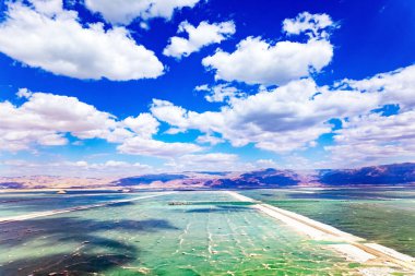  İsrail. Ölü Deniz. Kuş bakışı. Bulut gölgeleri suya yansıyor. Buharlaşmış tuz suyun üzerinde toplanır. Rahatlama ve tedavi için dinlenme yeri.