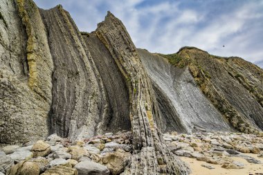 Cantabria Plajları, Portio Plajı. Dev, pürüzsüz gri kayalar ve pürüzsüz kumsal. İspanya 'nın Playa di Arnia plajında öğle vakti. Atlantik kıyısında rüzgarlı bir gün. 