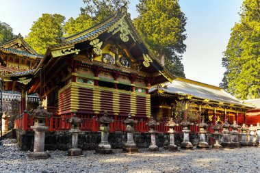 Ornate splendid temple. The even rows of stone sculptures - lanterns. Nikko Tosho-gu is a Shinto shrine in Nikko. National Treasure of Japan.  clipart