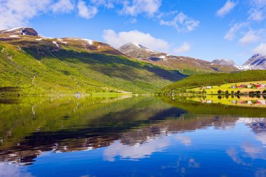 Eidsvatnet Gölü. Su mavi gökyüzünü ve ormanlı kıyıları yansıtır. Norveç 'in merkezindeki resimli dağlar. İskandinavya 'da yaz. 