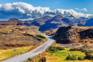 Şili Patagonya 'ya destansı bir gezi. Amerika 'nın güney ucundaki olağanüstü manzaralar. And Dağları. Tepeler arasındaki toprak yol. Torres del Paine Ulusal Parkı.