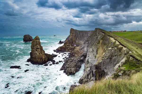 stock image Cantabria. Windy stormy day on the Atlantic coast. Rocky picturesque ocean coast. Noon on the beach of Playa di Arnia, Spain. Powerful surf waves with a foam crest. 