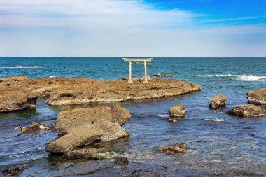 Oarai Isosaki Tapınağı 'nın torii kapısı. Resimli kayalık Pasifik kıyısı. Tanrıların Kıyısı 'na geçit. Tapınak, Japonya 'yı yaratan iki kutsal tanrının onuruna inşa edildi.