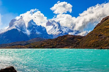 Pehoe Gölü 'ndeki köprü. Los Kuernos 'un karla kaplı siyah uçurumları. Eriyen buzulların suyunun gök mavisi var. Chiles Patagonia. Torres del Paine Ulusal Parkı.