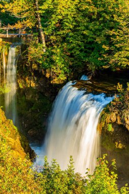 Warm summer sunset. Picturesque various cascading waterfalls. Croatia. The small friendly town of Slunj - Rastoke. Charming old Europe.  clipart