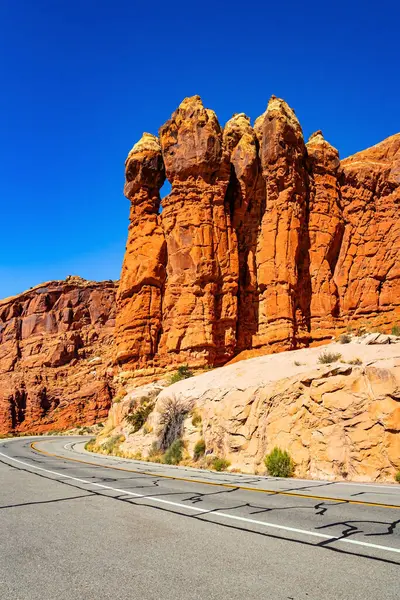 stock image Courthouse Towers. The brightest and most picturesque park of the Arches. USA. The asphalt highway passes through the most interesting majestic compositions created by wind and water.