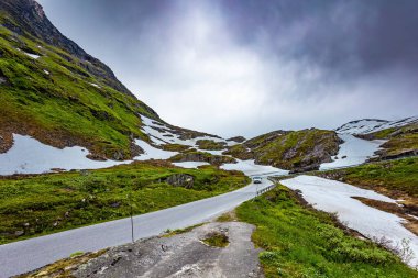 Norveç 'te büyülü yerler. Djupvatnet Gölü 'ne giden yol. Dağlar yeni yağmış karla kaplıdır. Norveç 'e yaz gezisi. Kar Kraliçesi 'nin sarayına giden yol.. 