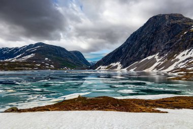 Temmuz ayında Djupvatnet Gölü buzla kaplıdır. Kar Kraliçesi Krallığı. Dağlar yeni yağmış karla kaplıdır. Norveç 'e yaz gezisi