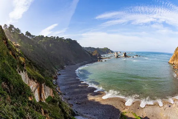  Dalgaların dantelli köpüğü. Asturias 'taki resim plajı. Playa del Silencio. Şeffaf gök mavisi su ve Atlantik Okyanusu 'nun küçük dalgaları. İspanya. 