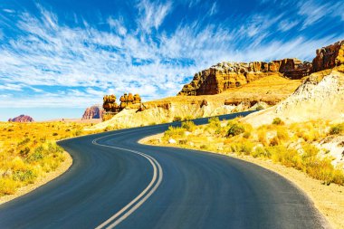 The fantastic landscapes of Goblin Valley Park. The asphalt highway winds through soft red-brown sandstone. Soft red-brown sandstone have created mushroom-shaped hoodoos. USA.  clipart