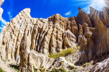 Yeni Zelanda 'nın zirveleri. Yeni Zelanda, Omarama Clay Cliffs. Fotoğraf Fishai lens ile çekildi. Çamur, alüvyon ve çakıldan oluşan görkemli kayalar. Parlak güneş ve açık mavi gökyüzü 